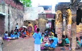 Students of Government Primary School, Jwalapur 5, attend a class in the open due to a poor condition of the school building in Haridwar