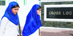 Girls walk past the LoC trade centre office in Poonch.