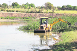A JCB machine at work on Jatani Talab, a pond at Baran village, in Jammu. 