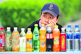 A woman sells soft drinks at a stall in Beijing on Sunday. China will ease monetary policy and boost liquidity in the financial system with a series of measures, state media cited a central bank official as saying, in a bid to avoid a sharp economic slowdown. 