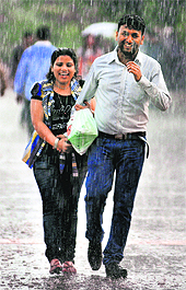 A couple breaks out into a laugh after being caught in the sudden rain at the Sukhna Lake in Chandigarh on Sunday evening.