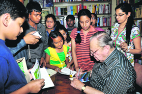Ruskin Bond gives autographs to his young fans in Dehradun on Saturday. 
