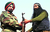A militant hands over his weapon to an officer during surrender ceremony