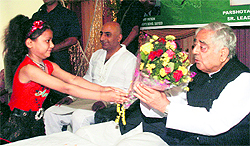 A girl presents a bouquet to Mufti Mohammad Sayeed, PDP patron and former Chief Minister, during an interaction programme with Kashmiri Pandits in Jammu on Sunday