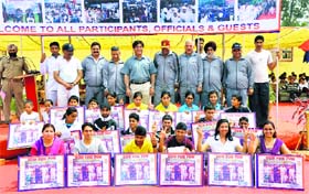 Police officers and winners of the marathon pose for a photograph in Jammu on Sunday