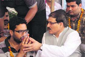 Mubarak Gul, Adviser to the Chief Minister, offers a glass of juice to a member of the Jammu Kashmir Agriculture Technocrats Association in Jammu on Sunday