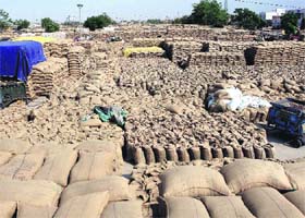 Wheat bags lie in the open in Rajpura grain market