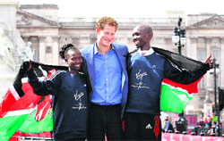 Britains Prince Harry poses with London Marathon winners Mary Keitany (left) and Wilson Kipsang, both from Kenya, outside Buckingham Palace in London. 