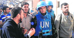 A man talks to a Moroccan UN observer in Khalidiya district of Homs on Saturday.