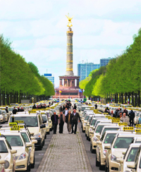 Taxis line a thoroughfare in central Berlin during a strike by cab drivers against new tariffs for journeys to and from Berlins new Brandenburg International Airport (BER) in Schnefeld, south of the German capital, on Monday. In the background is the Siegessaeule (victory column). The new airport is scheduled to open on June 3