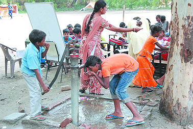 Students at a government school in Bathinda quench their thrist with the water from a handpump installed on the school premises.