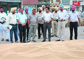 Bathinda Deputy Commissioner KK Yadav and other officials during a visit to the grain market on Tuesday.
