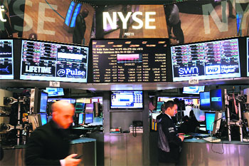 Traders work on the floor of the New York Stock Exchange on April 23. As investors continue to worry about events in Europe and signs of a slowdown in the Chinese economy, the Dow Jones Industrial Average ended the day down 102 points, or 0.8 per cent.