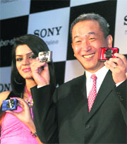 Sony India MD Masaru Tamagawa (R) with a model displaying Sonys Cyber-Shot Hi-zoom series digital still cameras at a launch in New Delhi on Tuesday. Sony is reinforcing its no. 1 slot in Indias digital camera market with an aim to corner a 45% share in FY12.