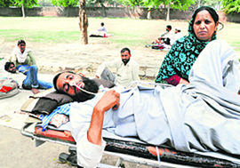 Mohammad Naseem of Saharanpur lies on a stretcher, with his sister sitting beside him.