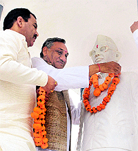 Chief Minister Vijay Bahuguna garlands the statue of his father Hemwati Nandan Bahuguna on his 93rd birth anniversary at his ancestral village Budhani in Pauri Garhwal on Wednesday