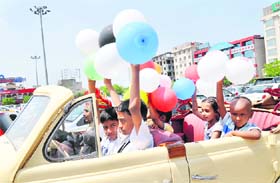 Children with special needs enjoy a ride in a vintage car on the occasion of 21 Gun Salute Restaurants first anniversary celebration at the Leisure Valley Park in Sector 29, Gurgaon, on Wednesday