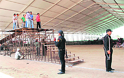 Security personnel oversee setting up of a podium at the venue