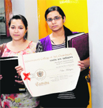 Neha Mahajan and another girl stand outside the office of the principal at the Arts College in Chandigarh on Thursday.