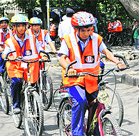 Students ride bicycles wearing helmet during a road safety workshop near the Sukhna Lake in Chandigarh on Thursday.