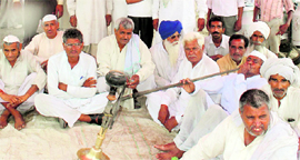 BKU president MS Tikait (smoking hookah) and other kisan leaders sit in dharna at Karnal on Thursday in protest against the ban on sale of wheat by UP farmers in Haryana.