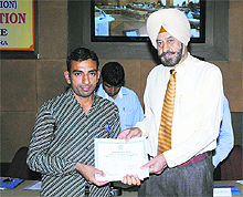 Lt-Gen (retd) Dr DDD Sandhu, Vice-Chancellor, Kurukshetra University, gives away a certificate of merit to a winner at the prize distribution function in Kurukshetra. 