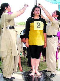 Women policemen measure the height of a candidate during the recruitment drive of jail staff conducted at PAU in Ludhiana on Thursday