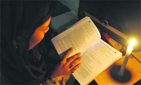 Power woes: A girl prepares for her exams under candle light in Patiala