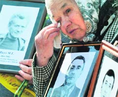 A widow cries as she holds a picture of her late husband, a victim of the Chernobyl nuclear accident, during a memorial ceremony in Kiev. 