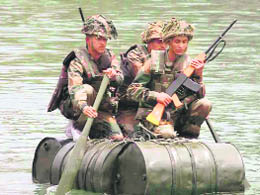 Army personnel of the Bengal Engineers Group perform a daring exhibition of war time and peace time on a boat made of diesel drums at the Ganga canal, Roorkee. 