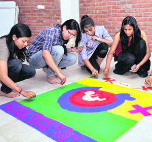 Students of the Institute of Management Studies take part in a rangoli competition during their annual festival in Dehradun on Friday. 