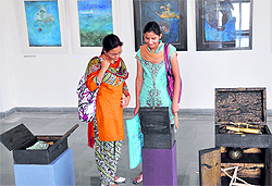 Girls look at the exhibits of sculptor Rajindra Tiku at Kala Kendra in Jammu on Friday