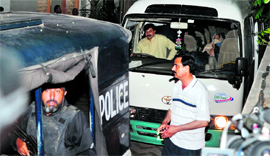 Policemen escort a mini-van carrying family members of Osama bin Laden in Islamabad.