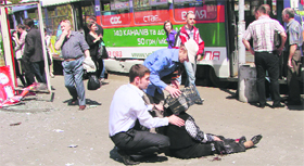 People assist an injured woman at a blast site in Dnipropetrovsk on Friday.