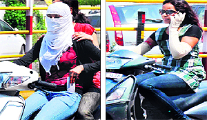 Girls use cellphones while driving in Haridwar on Saturday