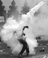 A protester throws back a tear gas canister fired by the police during a rally in Kuala Lumpur. 