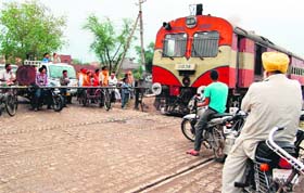 Human error: Commuters risk their lives trying to cross a level crossing in Amritsar