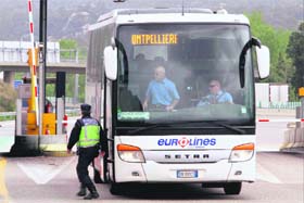 A border police officer walks around a bus arriving from France at the border crossing with Spain at La Jonquera on April 28