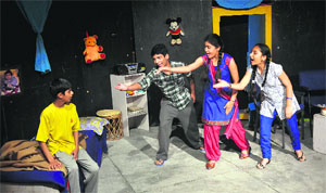 Artistes enact a scene from the play Na Ghar Ke Na Ghat Ke at Natrang Theatre in Jammu