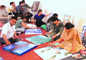 Artists paint during an art workshop at the Artmosphere Art Gallery in Ludhiana on Sunday.