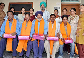 Principal of Dasmesh Senior Secondary School, Dr Ravinder Singh Mann, honouring class-IV employees of the school for their services in Bathinda on Monday.