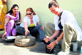 Members of a US students delegation try their hands on rural items during their visit to a village in Faridabad.