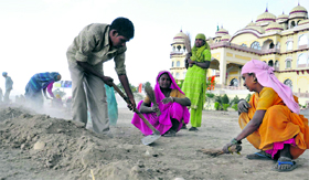 Labourers work at a road construction site on the eve of May Day in Karnal.