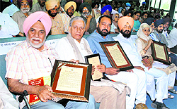 Punjabi play writer Ajmer Singh Aulakh, Khalid Khan, Kewal Singh Dhaliwal and Surjeet Kaur Chahal after being honoured during the 5th All-India Punjabi Conference in Patiala on Monday.