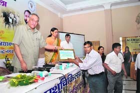 Chief Minister Vijay Bahuguna honours a veterinary doctor during a function in Dehradun on Tuesday