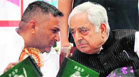 Patron of the Peoples Democratic Party Mufti Mohammad Sayeed discusses a point with Jammu and Kashmir Peoples Democratic Trade Unions president Suresh Sharma during a function on May Day in Jammu on Tuesday.
