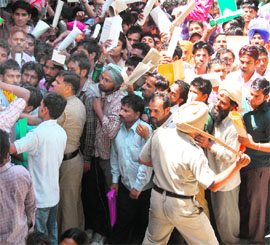 Police resort to a mild lathicharge to control the crowd at a recruitment rally organised by the MC to recruit safai karamcharis in Amritsar on Wednesday. 
