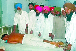 Sardulgarh MLA Ajitinder Singh Mofar enquiring about the well-being of the Congress worker undergoing treatment at Mansa Civil Hospital. The worker was allegedly beaten up by the Mansa police
