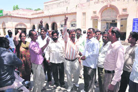 Safai karamcharis hold a demonstration after locking the offices on the Dehradun Municipal Corporation premises on Wednesday.