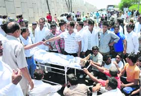 Relatives of Hukam Singh, who died under mysterious circumstances in the Civil Hospital, block NH1 with his body near Nirmal Kutia Chowk in Karnal on Wednesday